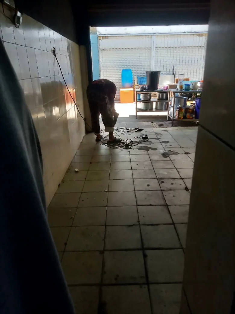 工人在走道拆除旧地砖,为 Renovix Home Services 的铺砖工程作准备。