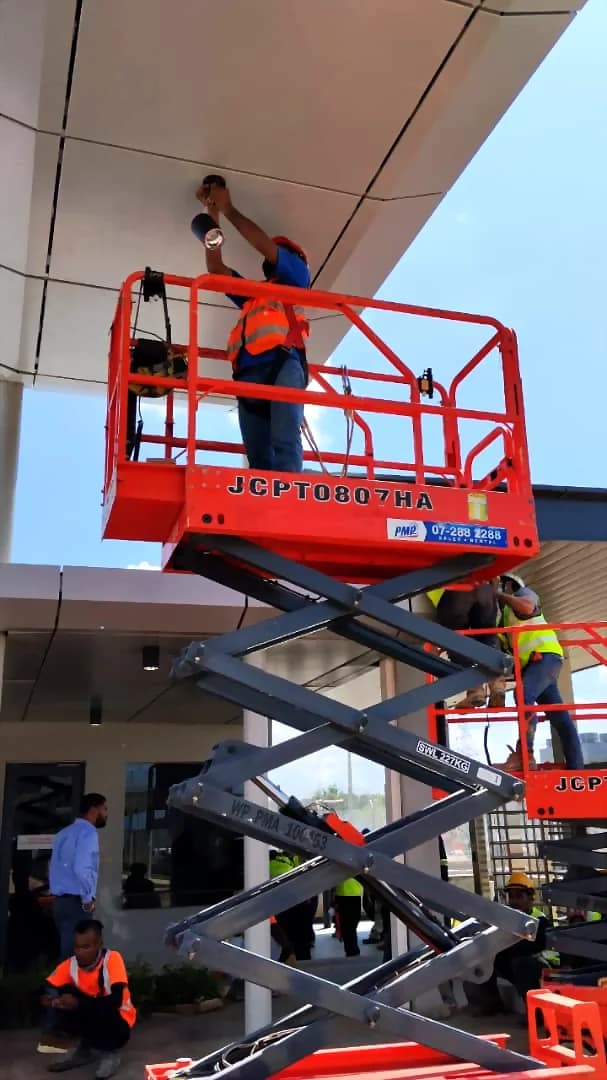 Electrician installing high-level lighting from a scissor lift for Renovix Home Services in Klang Valley.