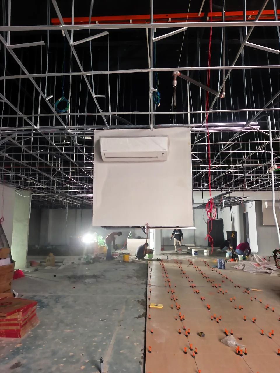Office interior under renovation with ceiling framing and floor tiling in progress by Renovix Home Services.