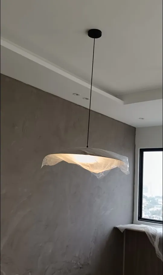 Renovix Home Services 在巴生谷水泥纹理背景墙客厅中安装的黑色细杆吊灯。